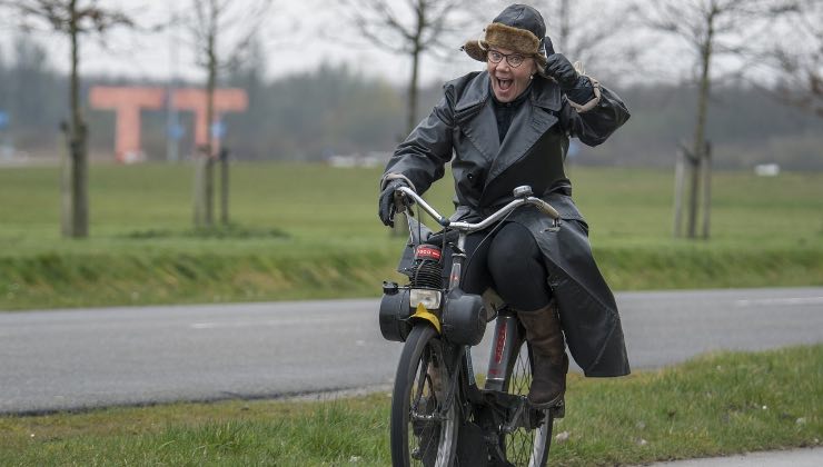 Donna si diverte a spostarsi nel verde con la bicicletta 